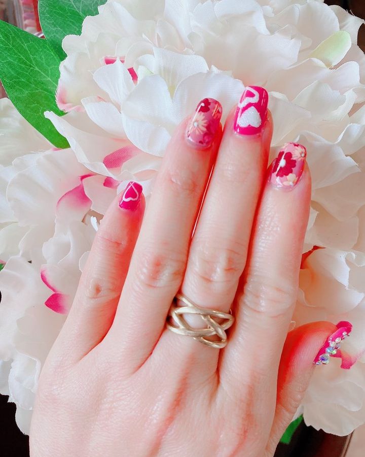 Sheer pink nails with hand-painted pink and red floral designs