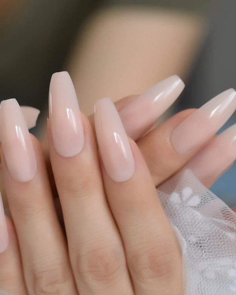 Long nude coffin-shape nails with a glossy finish, from a Queen's Nails client photo